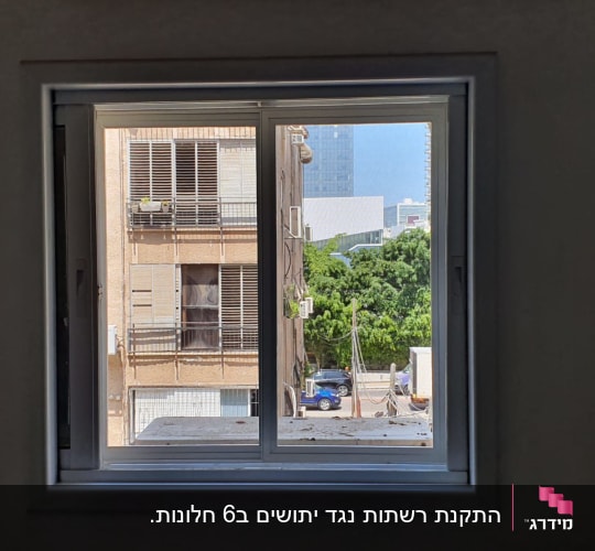 חלון אלומיניום עם נוף עירוני ברקע